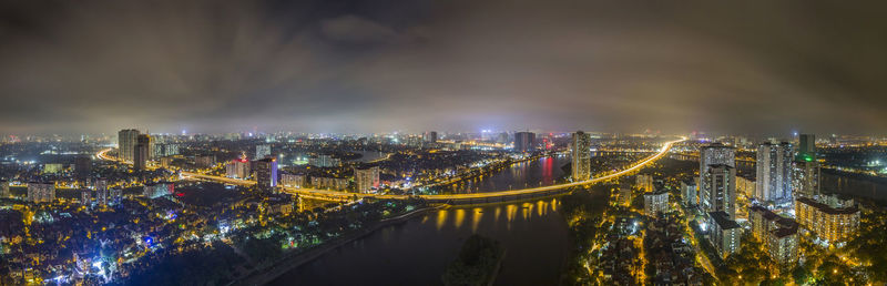 High angle view of illuminated city by river at night