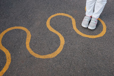 Low section of person standing on road