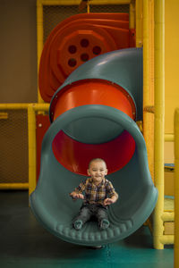 Full length of cute girl sitting at playground