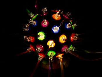 Close-up of illuminated lighting equipment against black background