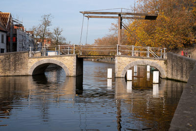 Arch bridge over river against sky