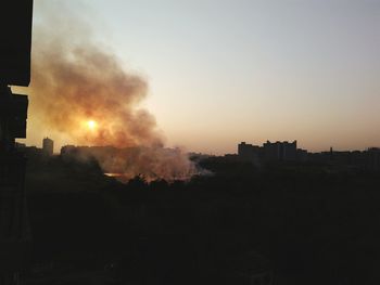 Silhouette city against sky during sunset