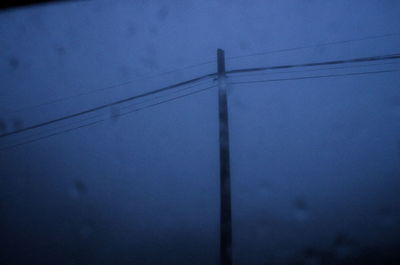 Low angle view of electricity pylon against blue sky