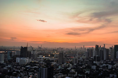 Aerial view of modern buildings in city against sky during sunset