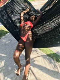 Woman in bikini leaning on hammock