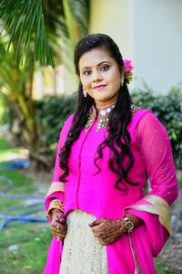 Portrait of smiling bride in traditional clothing standing outdoors