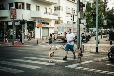People with dog on road in city