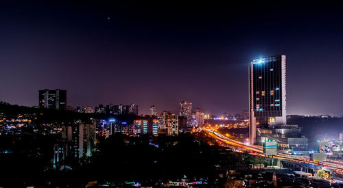 Illuminated cityscape against sky at night