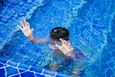 High angle view of boy drowning in swimming pool