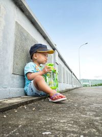 Little boy resting while drinking water in a bottle