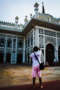 Full length rear view of woman walking in front of building