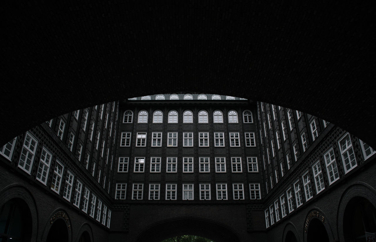 LOW ANGLE VIEW OF ILLUMINATED BUILDING AGAINST SKY AT NIGHT