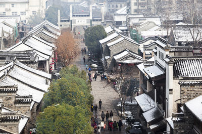 High angle view of people walking on road along buildings