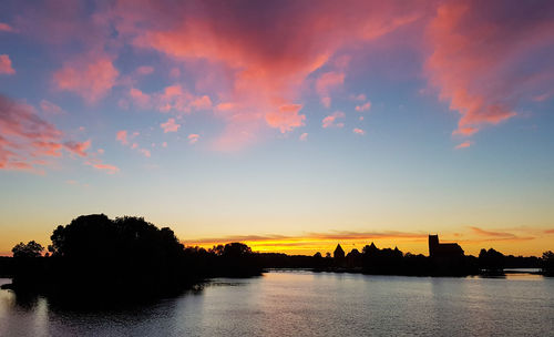 Scenic view of river against sky at sunset