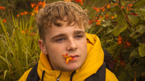 Close-up of teenage boy carrying flower in mouth