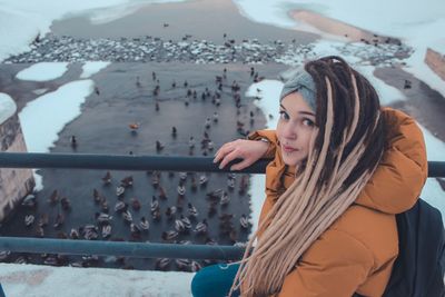 Portrait of woman standing by railing