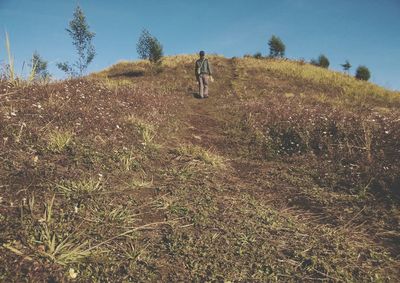 Full length of woman standing on field against sky