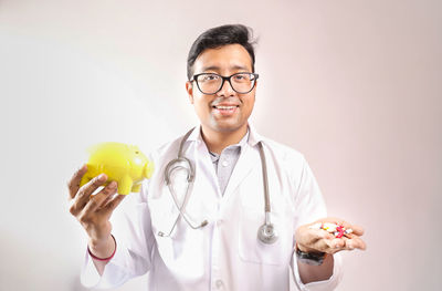 Portrait of smiling man wearing mask against white background