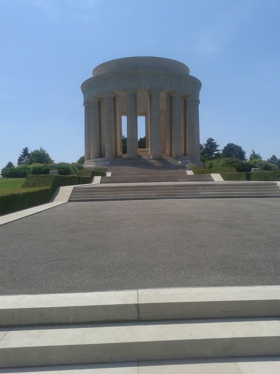 architecture, built structure, building exterior, history, famous place, clear sky, travel destinations, travel, blue, tourism, sky, low angle view, sunlight, the way forward, monument, road, day, architectural column, the past, incidental people