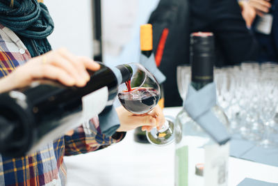 Midsection of woman holding wine glass