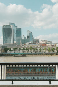 Railroad tracks by buildings in city against sky