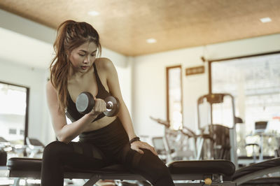 Woman lifting dumbbell in gym