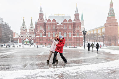 Full length of people on snow covered city