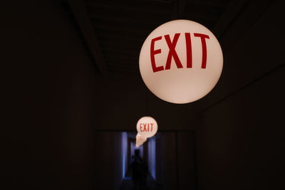 Low angle view of woman standing against illuminated sign