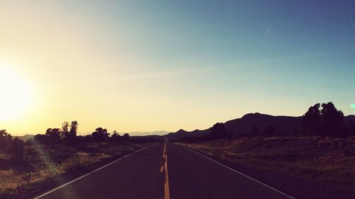 Empty road along landscape against clear sky