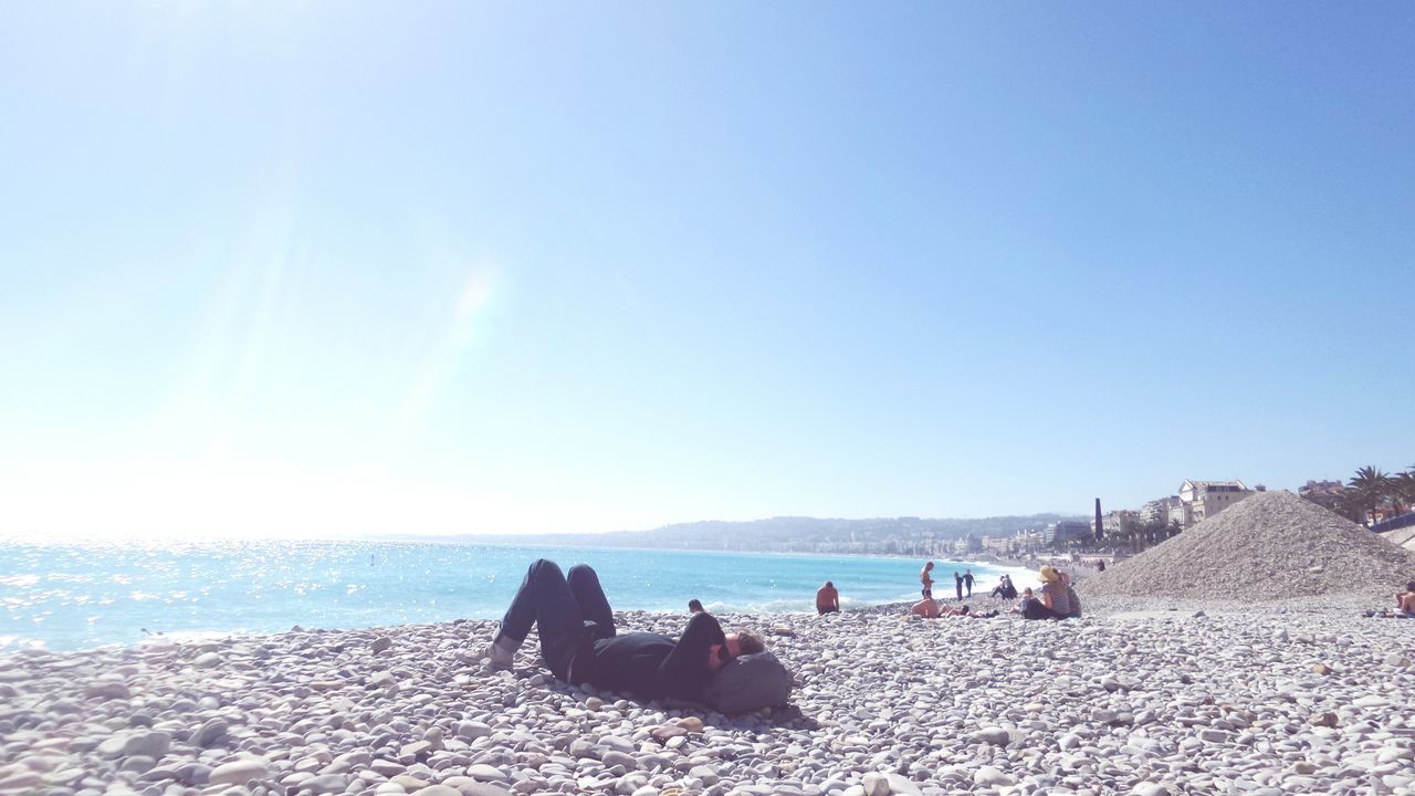 sea, clear sky, copy space, beach, water, blue, vacations, scenics, leisure activity, lifestyles, sand, tranquility, tranquil scene, sunlight, large group of people, men, tourist, horizon over water, beauty in nature