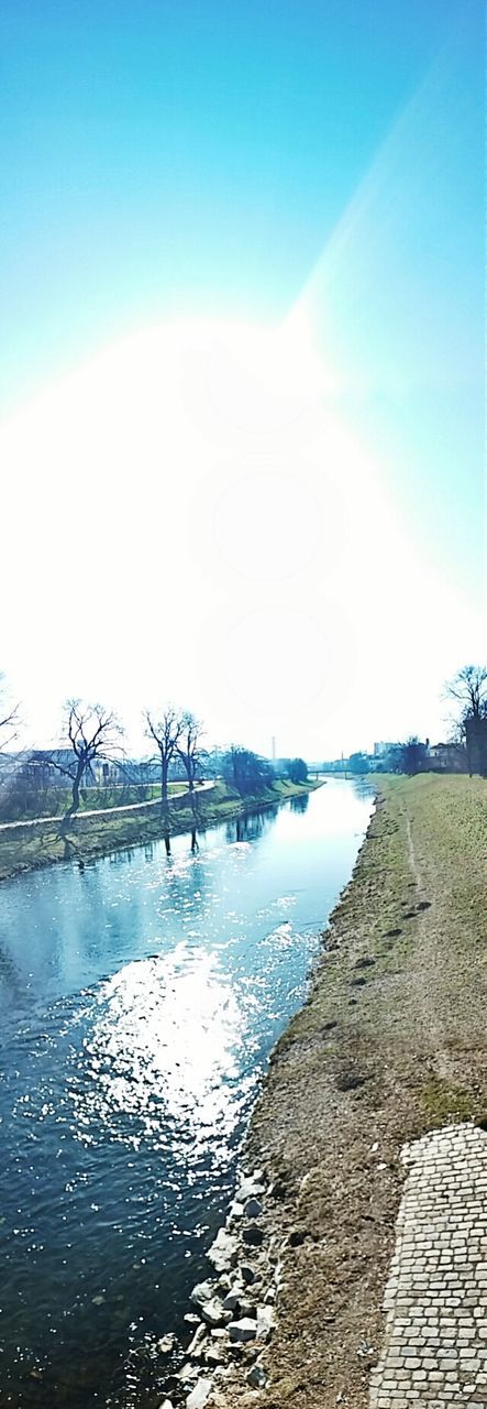 water, blue, tranquil scene, tranquility, sky, scenics, reflection, sunlight, beauty in nature, nature, river, clear sky, lake, day, outdoors, no people, built structure, copy space, sea, idyllic