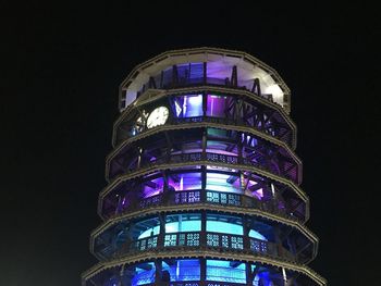 Low angle view of illuminated tower at night