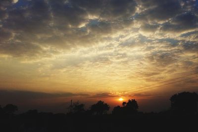 Scenic view of silhouette trees against romantic sky at sunset