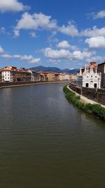 River amidst buildings in city against sky
