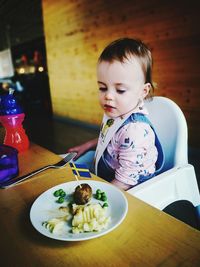 Boy eating food on table