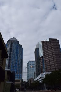 View of skyscrapers against cloudy sky