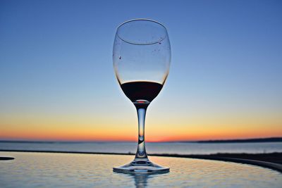 Red wine poured in a glass with evening view 