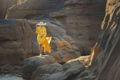 Rear view of man standing on rock formations