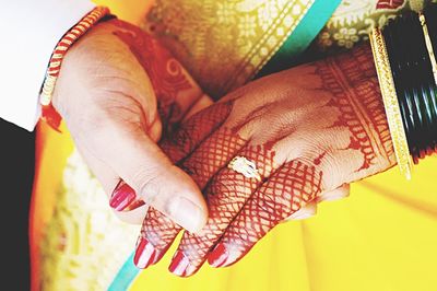 Midsection of newlywed couple holding hands