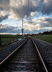 Railroad track against cloudy sky