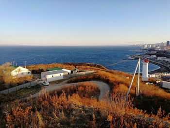 High angle view of city by sea against clear sky