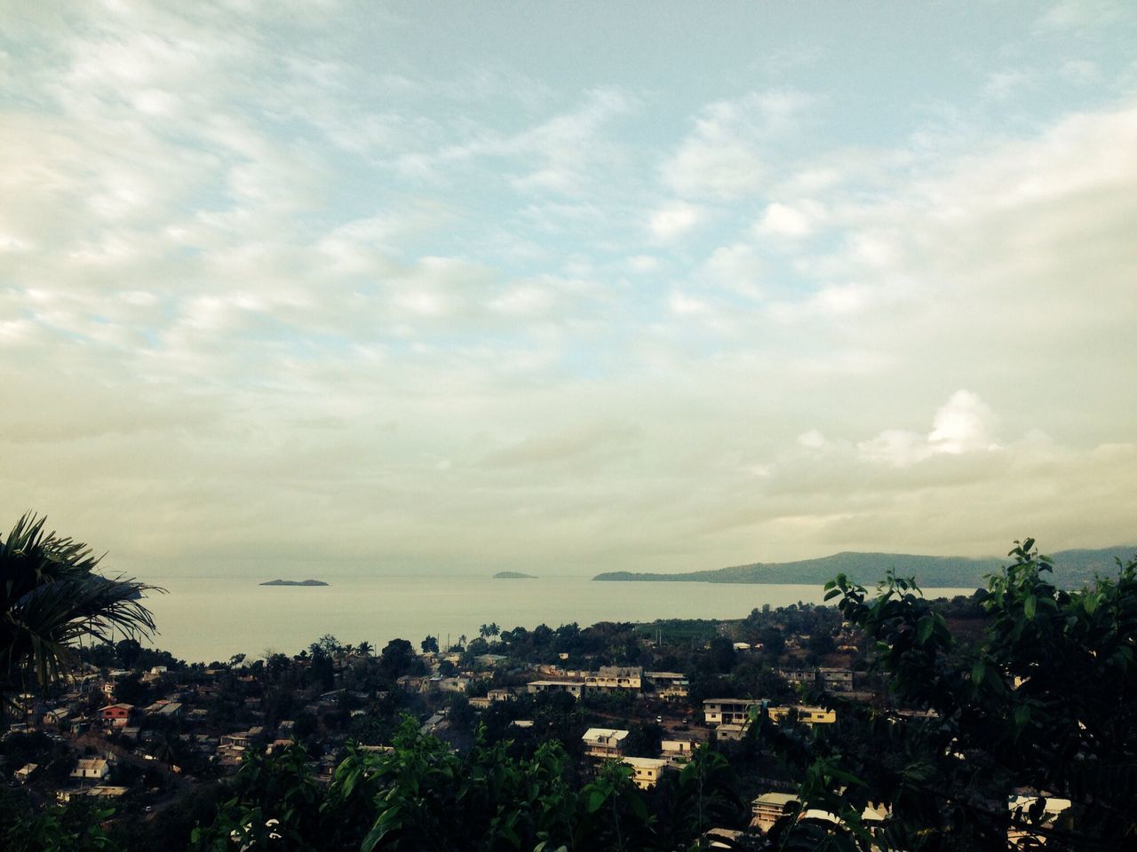 sky, building exterior, sea, architecture, built structure, water, cloud - sky, tree, cloudy, high angle view, horizon over water, house, scenics, residential structure, nature, cloud, residential building, town, beauty in nature, residential district