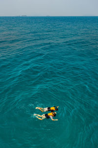 High angle view of people in sea against sky