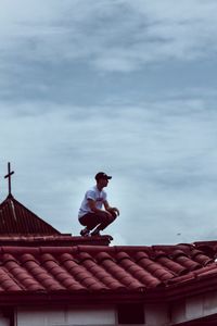 Man on roof against sky