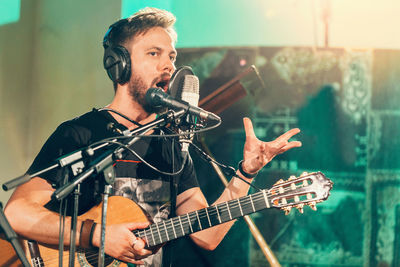 Close-up of man singing while playing musical instrument