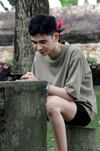 Side view of young woman looking away while standing outdoors
