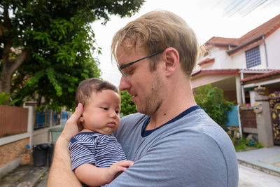 Father and son embracing while standing outdoors