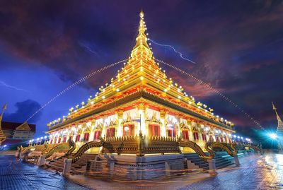 Low angle view of illuminated temple against cloudy sky at night