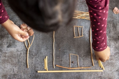 High angle view of girl playing with sticks on floor