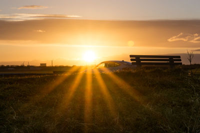 Car on field against sky during sunset